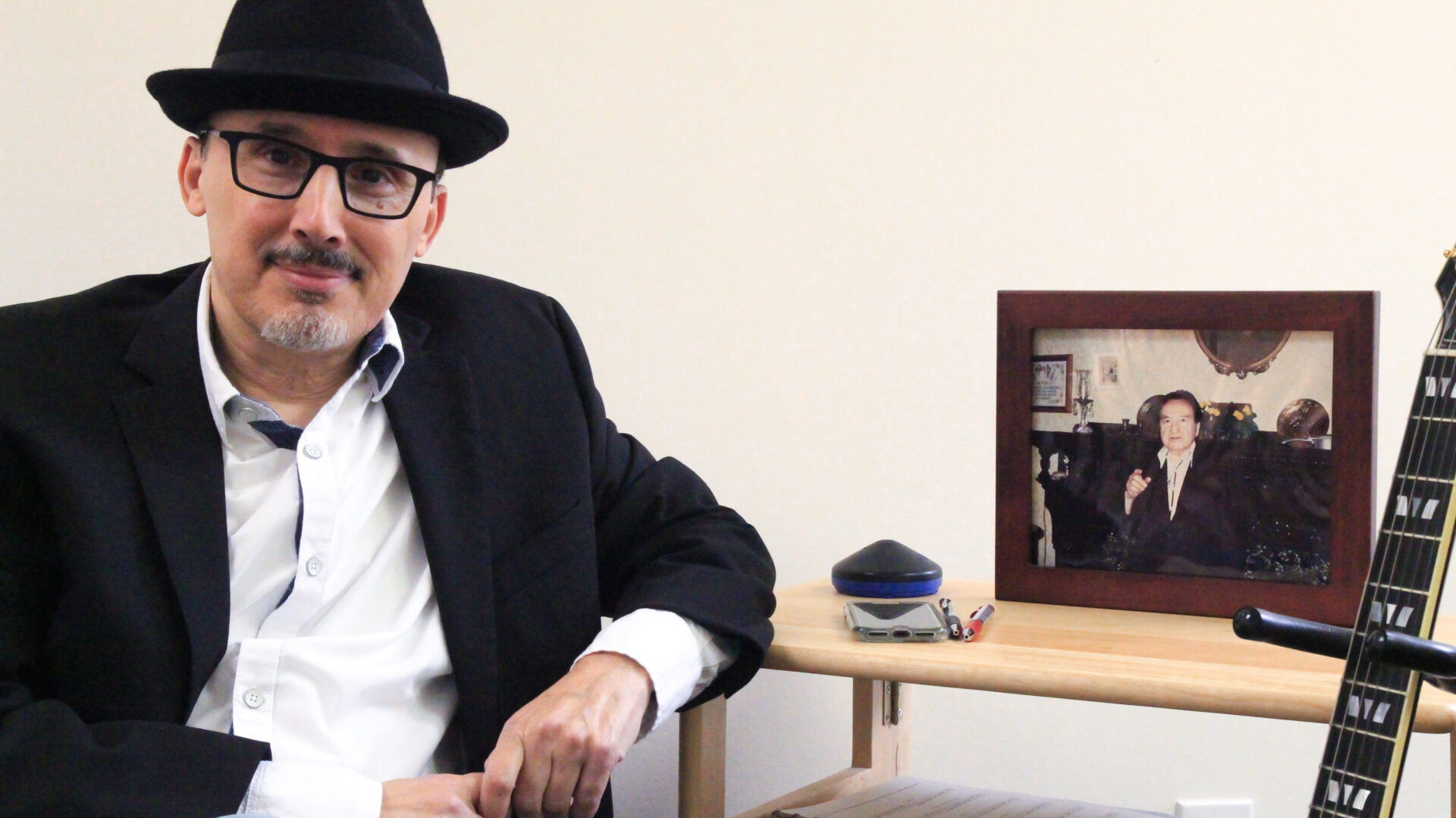 A man sitting in front of a picture.